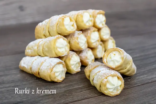 Rurki z ciasta francuskiego z kremem, oprószone cukrem pudrem